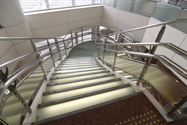 Modern stained and matted glass stairs with metallic hand-rails