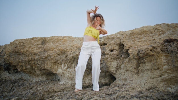 Modern style dancer moving body smoothly on stone rock woman performing dance