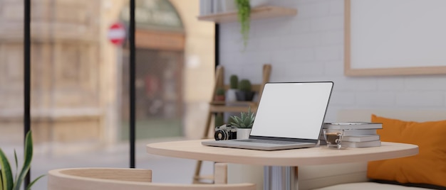 Modern stylish coffee shop interior with laptop computer on the table in seating area