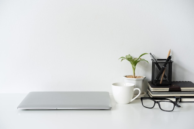 Modern and stylish workspace mock up with laptop and desk office supplies with white background and copy space