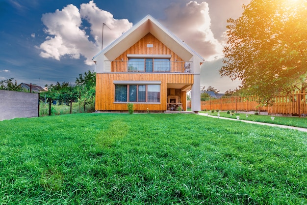 Modern summer cottage against a blue sky in the summer garden. Sunny day