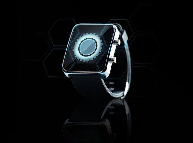 modern technology, settings, object and media concept - close up of black smart watch with cogwheel icon on screen