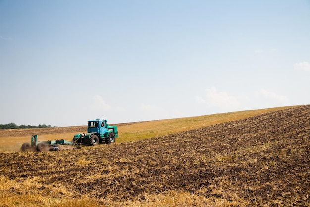 Modern tractor in the field with complex for the plowing The concept of work in a fields and agriculture industry