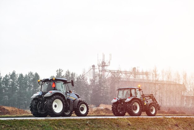 Photo modern tractor moving slowly on asphalt road to farm