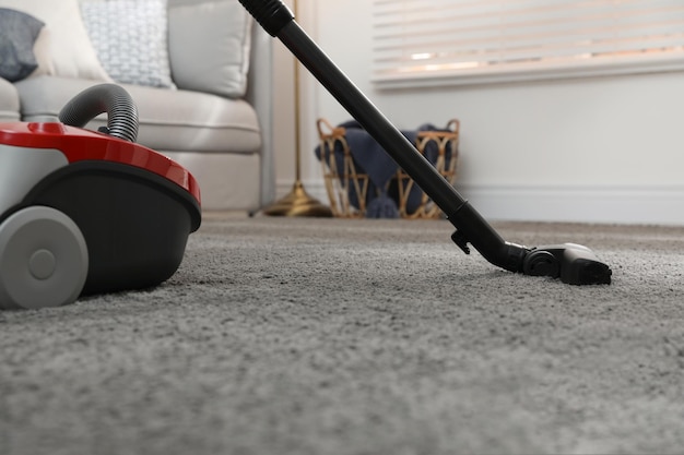 Modern vacuum cleaner on carpet at home