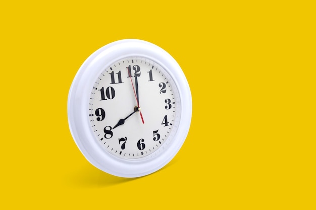 Modern wall clock white isolated on yellow background.