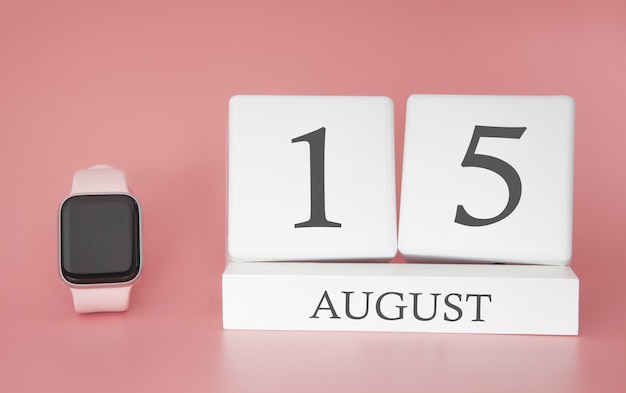 Modern Watch with cube calendar and date 15 august on pink wall. Concept summer time vacation.