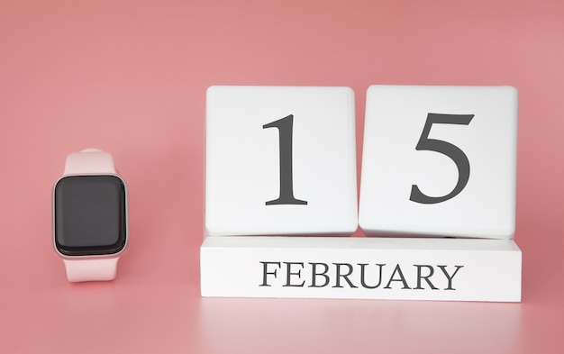 Modern Watch with cube calendar and date 15 february on pink background. Concept winter time vacation.