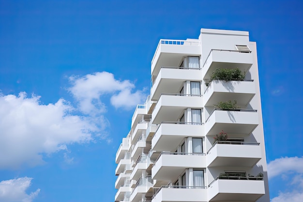 Modern White Apartment Building with Blue Sky and Clouds Plants and Lifestyle Elements