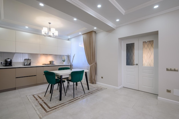 Modern white and beige large luxurious kitchen and dining table in studio apartment