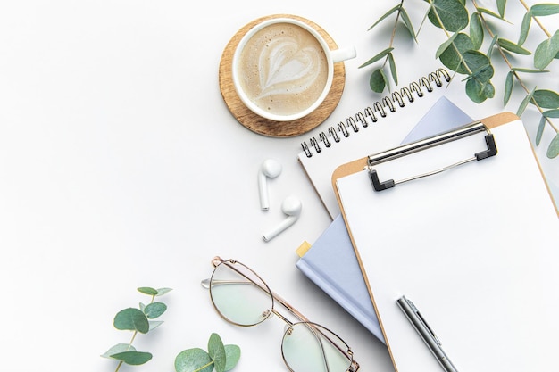 Modern white office desk table with coffee notebook and other supplies