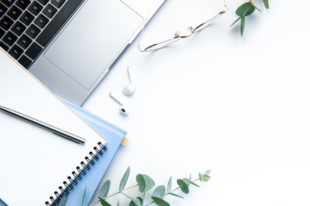 Modern white office desk table with laptop notebook and other supplies