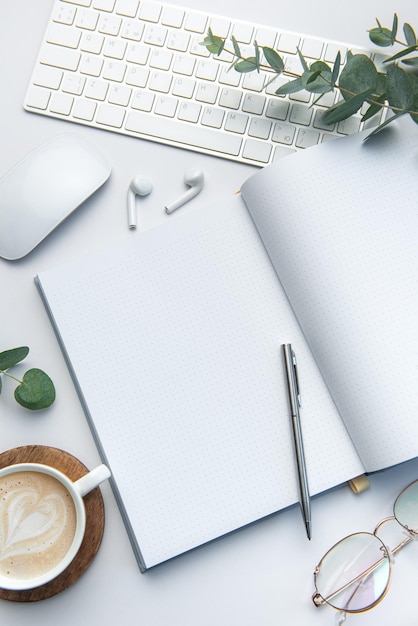 Modern white office desk table with laptop notebook and other supplies