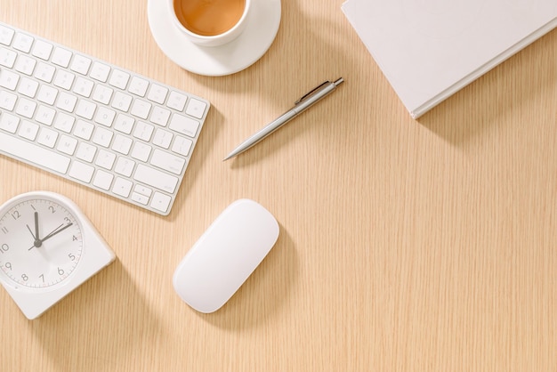 Modern white office desk with keyboard, mouse, oclock, book, pen and cup of coffee.Top view with copy paste. Business and strategy concept mockup.