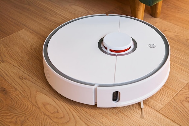 Modern white robotic vacuum cleaner washing floor