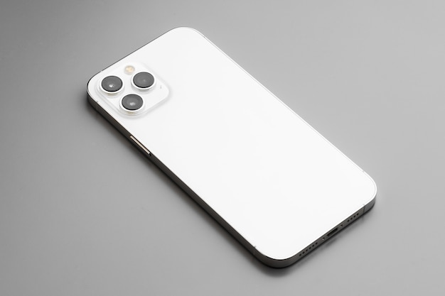 Modern white smartphone with triplelens camera on gray