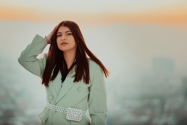 Modern woman in green jacket posing outside