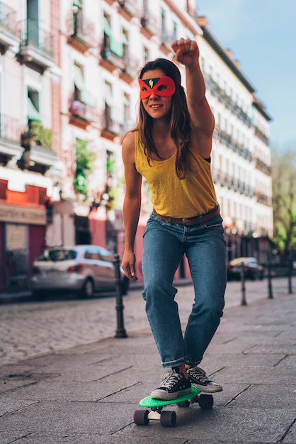 Modern woman heroine with mask in a skateboard. Superhero.