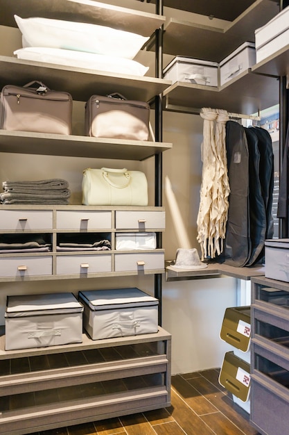 Modern wooden wardrobe with clothes hanging on rail in walk in closet 