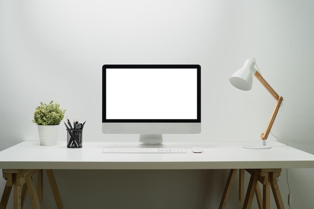 Modern workplace with bank screen of desktop computer on desk White empty screen for graphic display montage