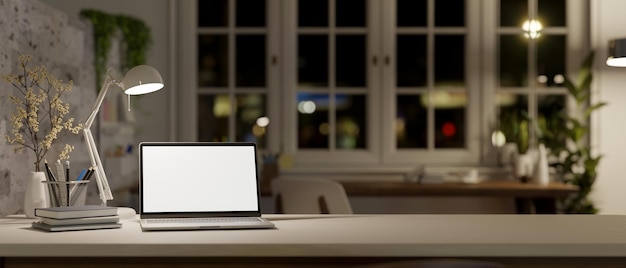 A modern workspace at night with laptop mockup table lamp books stationery and copy space