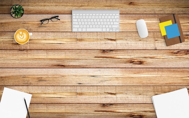 Modern workspace with coffee cup, paper, notebook, tablet or smartphone and keyboard on wood