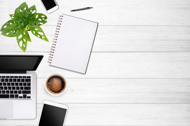 Modern workspace with laptop tablet smartphone and coffee cup copy space on white wood table