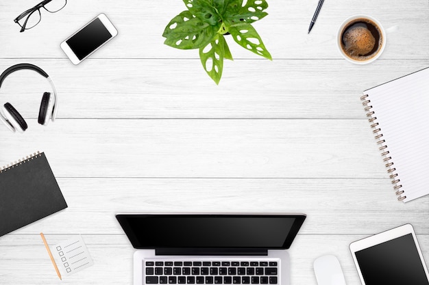 Modern workspace with laptop tablet smartphone and coffee cup copy space on white wood table