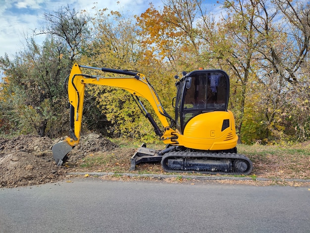 Modern yellow JCB digger or excavator performs excavation work outdoors