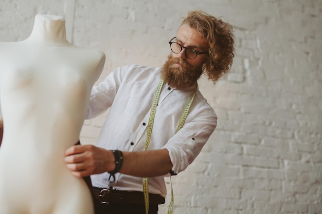 modern young clothing designer in the work process, a clothing designer with long hair and beard