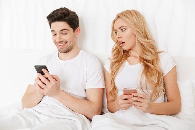 Modern young couple using mobile phones