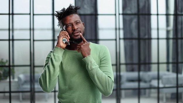 Modern young man with mobile phone in the office