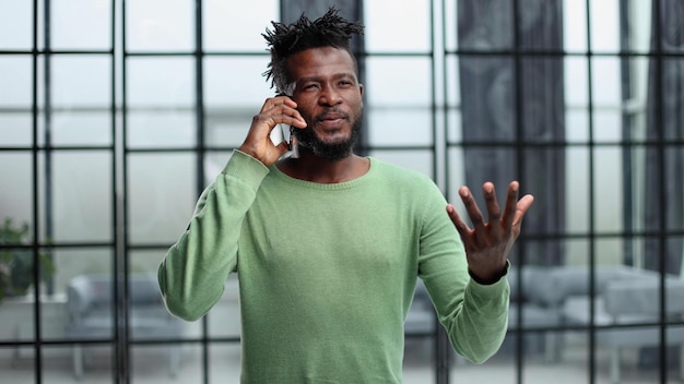 Modern young man with mobile phone in the office