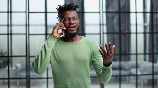 Modern young man with mobile phone in the office