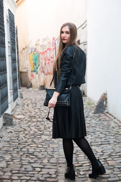 Modern young woman next to graffiti wall