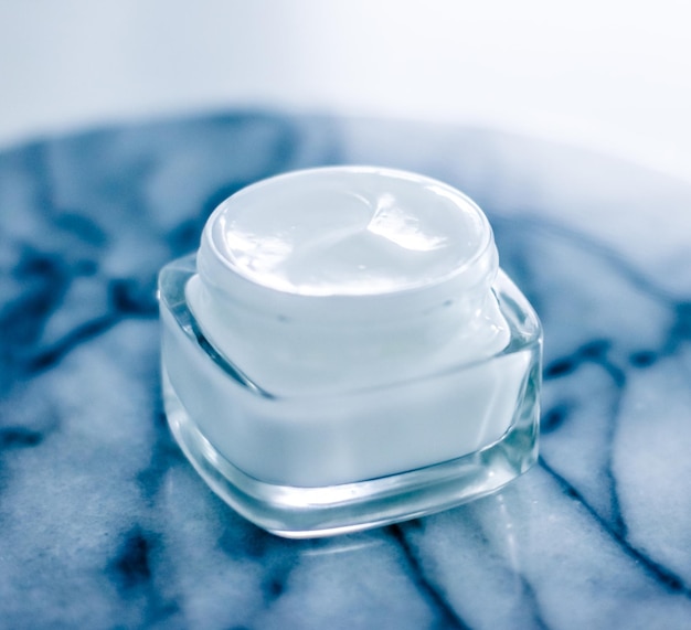 Moisturizing beauty face cream on blue marble stone skincare and spa cosmetics