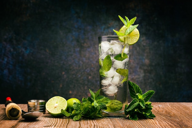 Mojito cocktail decorated with lemon and peppermint on a wooden table No straw