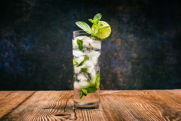 Mojito cocktail decorated with lemon and peppermint on a wooden table No straw