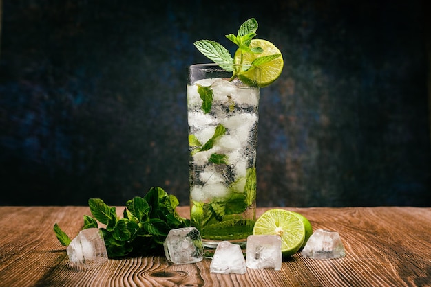 Mojito cocktail decorated with lemon and peppermint on a wooden table No straw