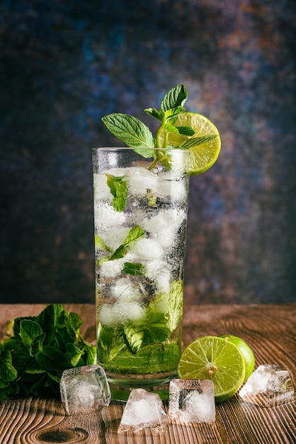 Mojito cocktail decorated with lemon and peppermint on a wooden table No straw