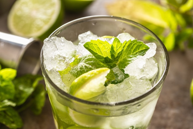 Mojito cocktail drink with white rum lime mint herbs and soda on the bar counter.