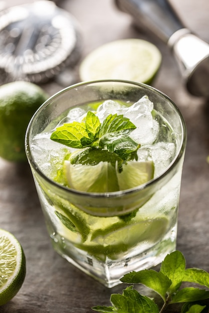 Mojito cocktail drink with white rum lime mint herbs and soda on the bar counter.