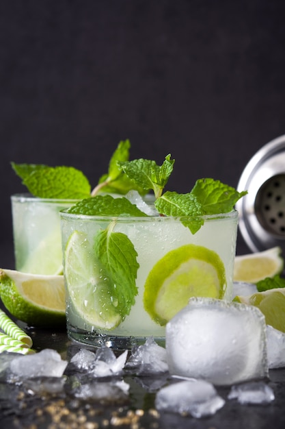 Mojito cocktail in glass with lime and mint on the stone