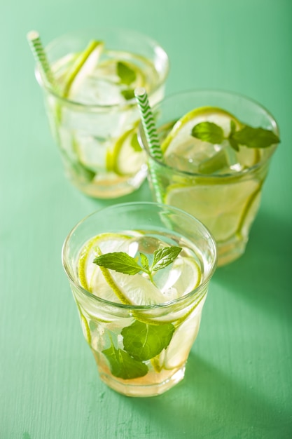 Mojito cocktail and ingredients over green table