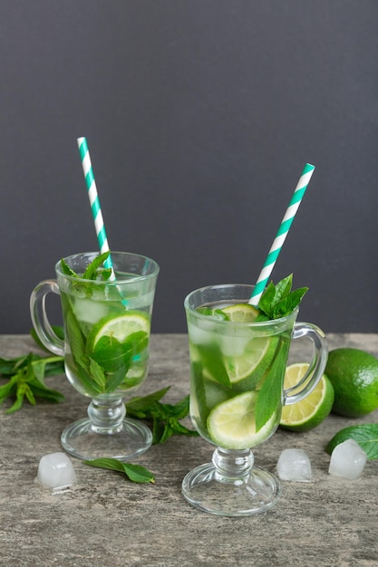 Mojito cocktail Refreshing mojito cocktail with lime lemon and mint in a tall glass with a stick