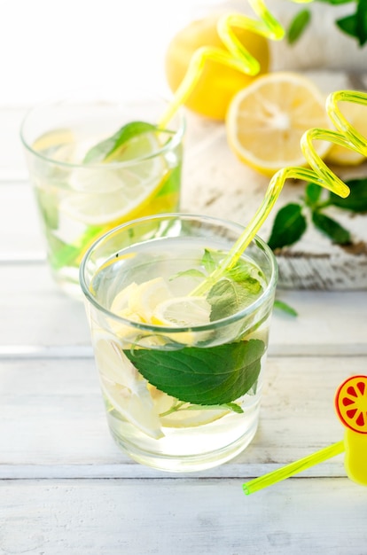 Mojito cocktail with lemons and mint on white table, cocktail summer drinks concept