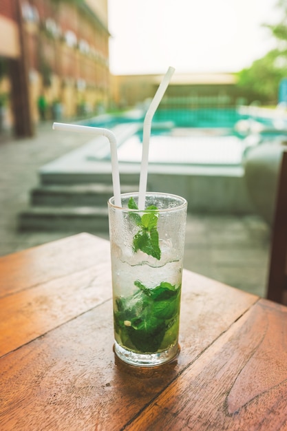 Mojito cocktail with lime and mint in a glass on the table