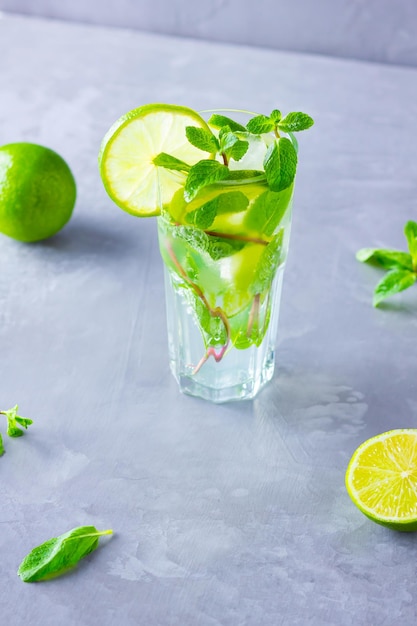 Mojito cocktail with lime and mint in tall glass Fresh mojito in glass on a gray background