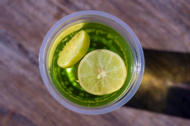 Mojito drink in a plastic cup on wooden table background , top view, Egypt