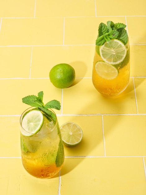 Mojito or virgin mojito long rum drink with fresh mint lime juice cane sugar and soda On yellow background